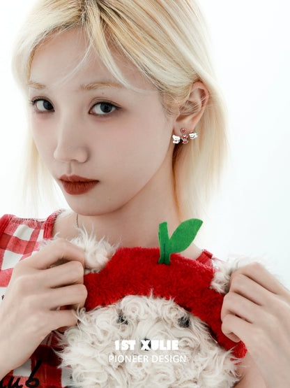 Model wearing sweet apple pet removable earrings while holding a plush apple toy