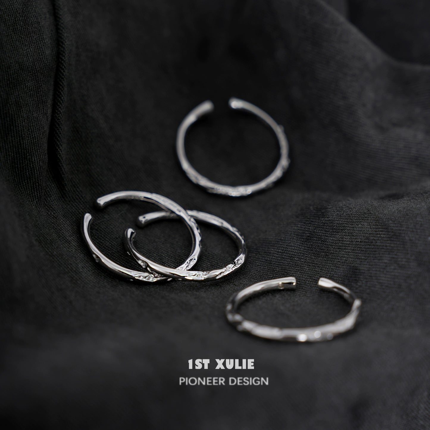 Set of four elegant textured silver rings with unique designs, perfect for stacking or solo wear