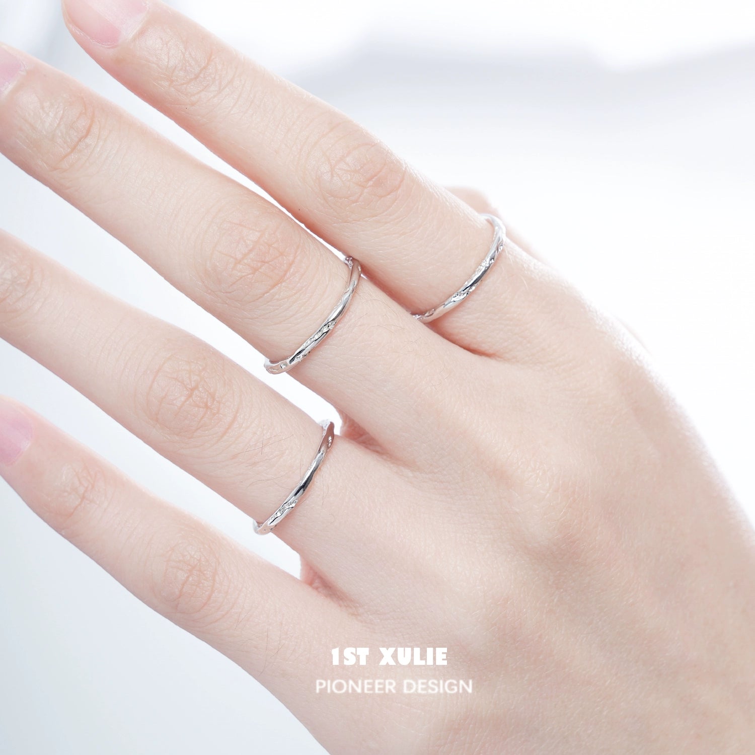 Set of three textured silver rings stacked on a model's hand for stylish jewelry layering