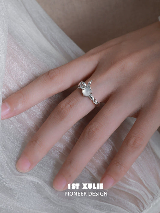Elegant white agate butterfly silver ring showcased on a hand with a soft fabric background