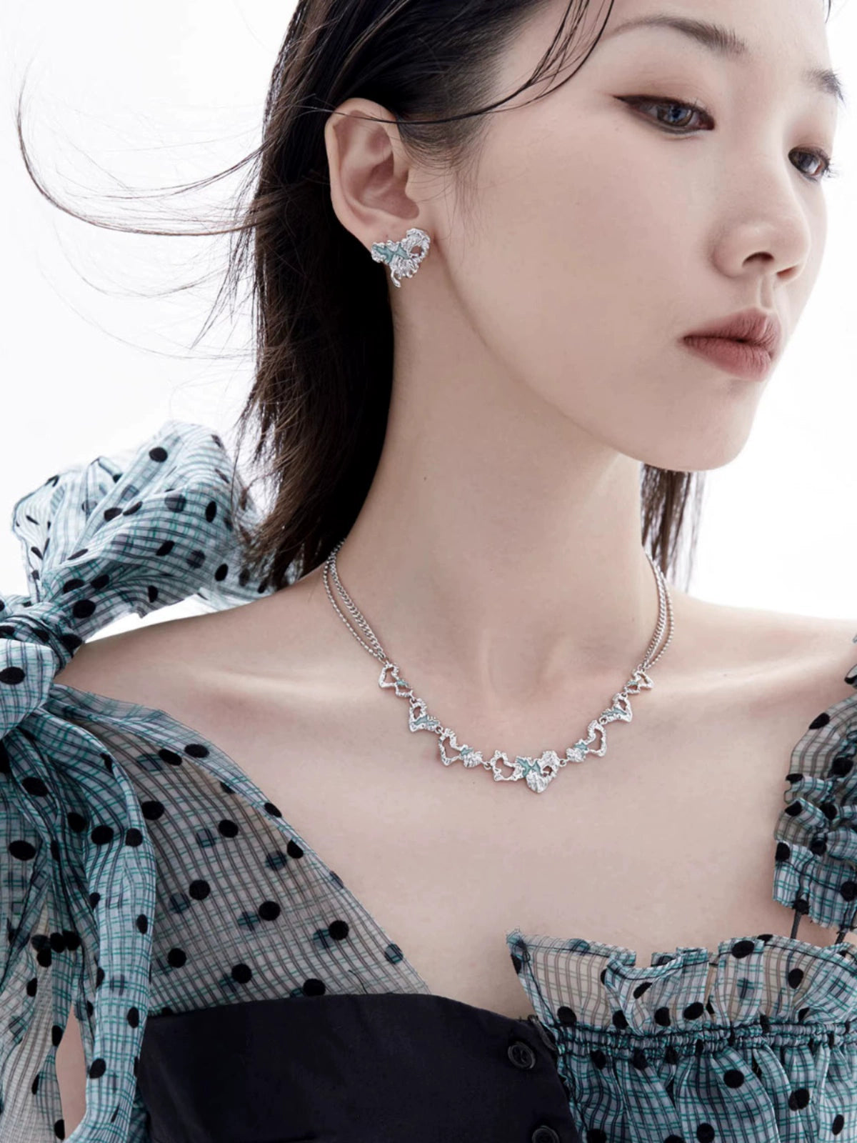 Y2K melting love earrings in silver, complemented by matching jewelry on a model