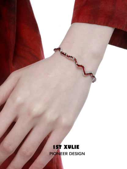 Y2K red silver bracelet with a wavy design showcased on a hand