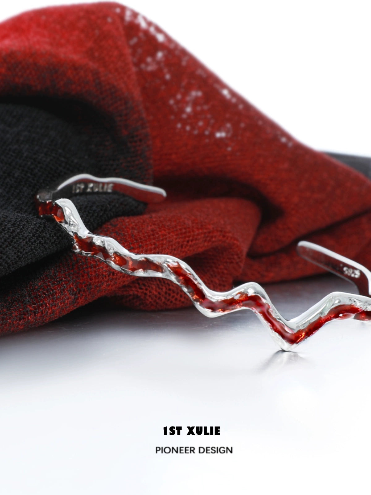 Y2K red silver bracelet on a textured red and black fabric background showcasing its unique design