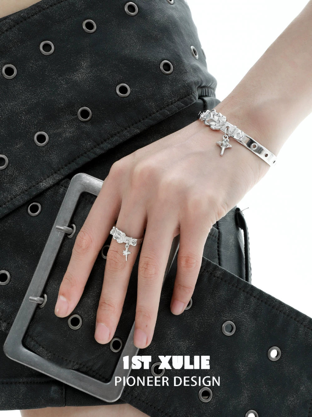 Y2K silver belt bracelet featuring unique charms, stylishly worn on a hand with a ring