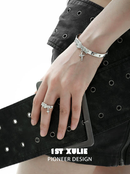 Y2K silver belt bracelet worn on a hand with a black studded skirt for a trendy look