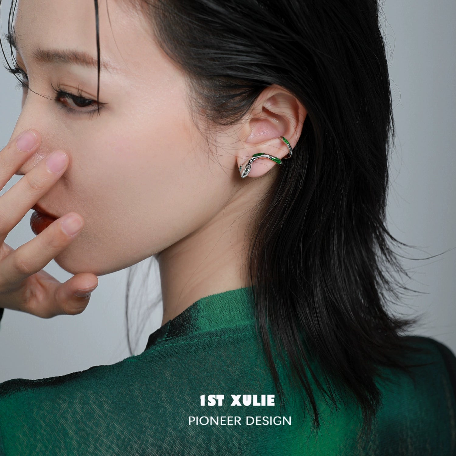 Y2K Slytherin snake earrings showcased on a model with dark hair and a green outfit