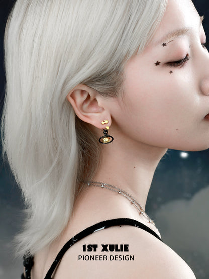Y2K star earrings in gold and black, styled on a model with silver hair for a trendy look