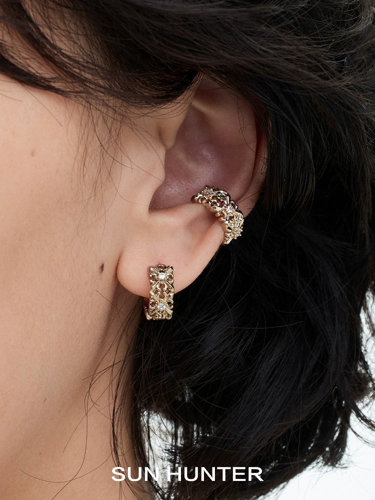 Close-up of a vintage iris ear cuff in gold worn on an ear, showcasing detailed design by SUN HUNTER