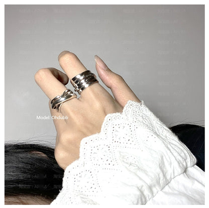 Stylish hand wearing multiple silver rings including a bandage wrap punk ring for a trendy look