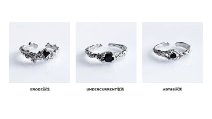 A black crown ring featuring intricate detailing and a central black gemstone for a unique style