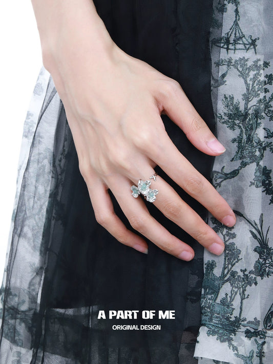 A Part of Me blue flower ring featuring a delicate design with floral elements, worn on a hand