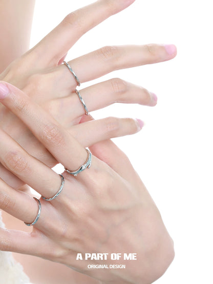 Collection of elegant silver rings featuring a blue minimalist ring on delicate fingers