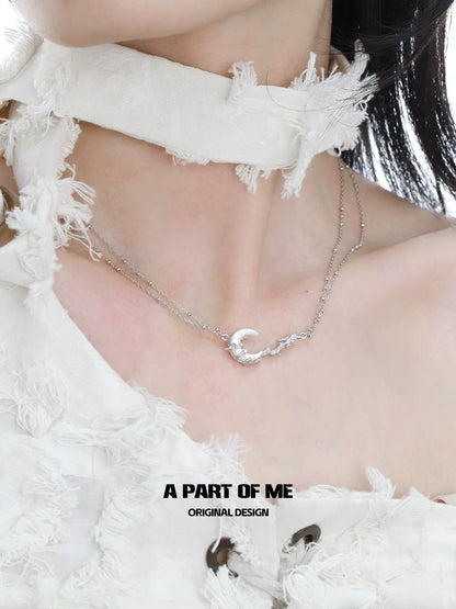 A PART OF ME silver crescent moon necklace elegantly worn on a model's neck