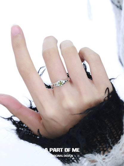 A hand wearing a delicate dreamy star ring with a silver setting and a unique gemstone design
