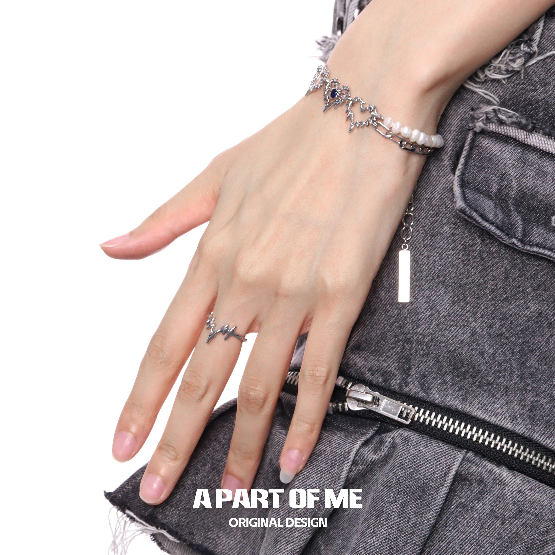 Electrocardiogram wave silver ring on a model's hand with stylish denim outfit