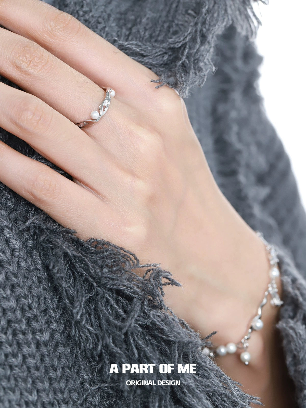 A PART OF ME pearl statement ring featured on a hand with a cozy grey knit sweater