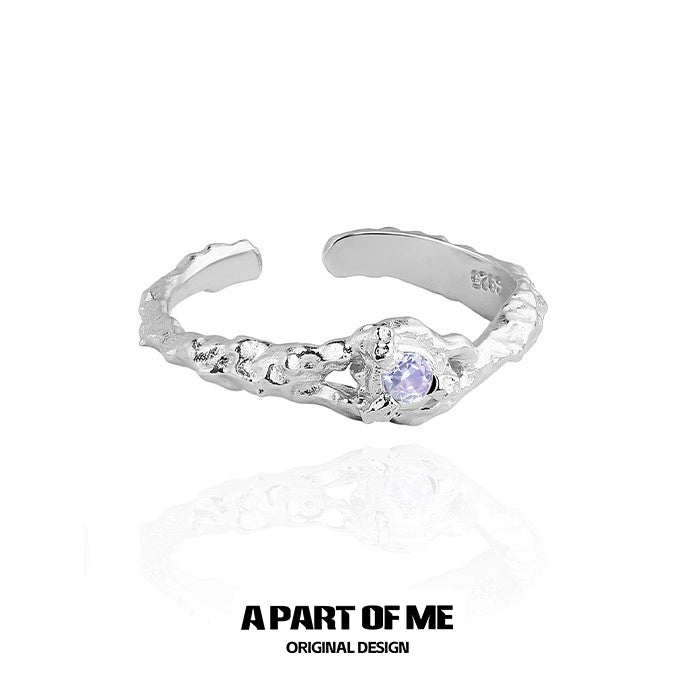 A PART OF ME silver wave ring featuring a purple zircon stone in a textured design