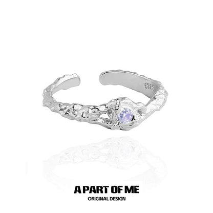 A PART OF ME silver wave ring featuring a purple zircon stone in a textured design