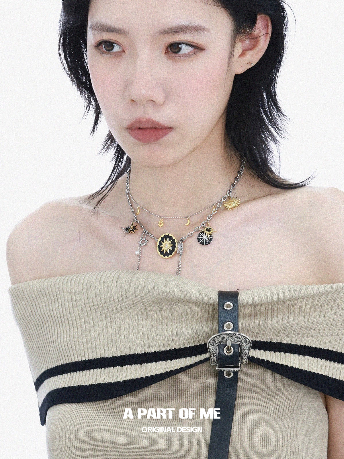 A PART OF ME sun and moon necklace featuring intricate designs with celestial charms