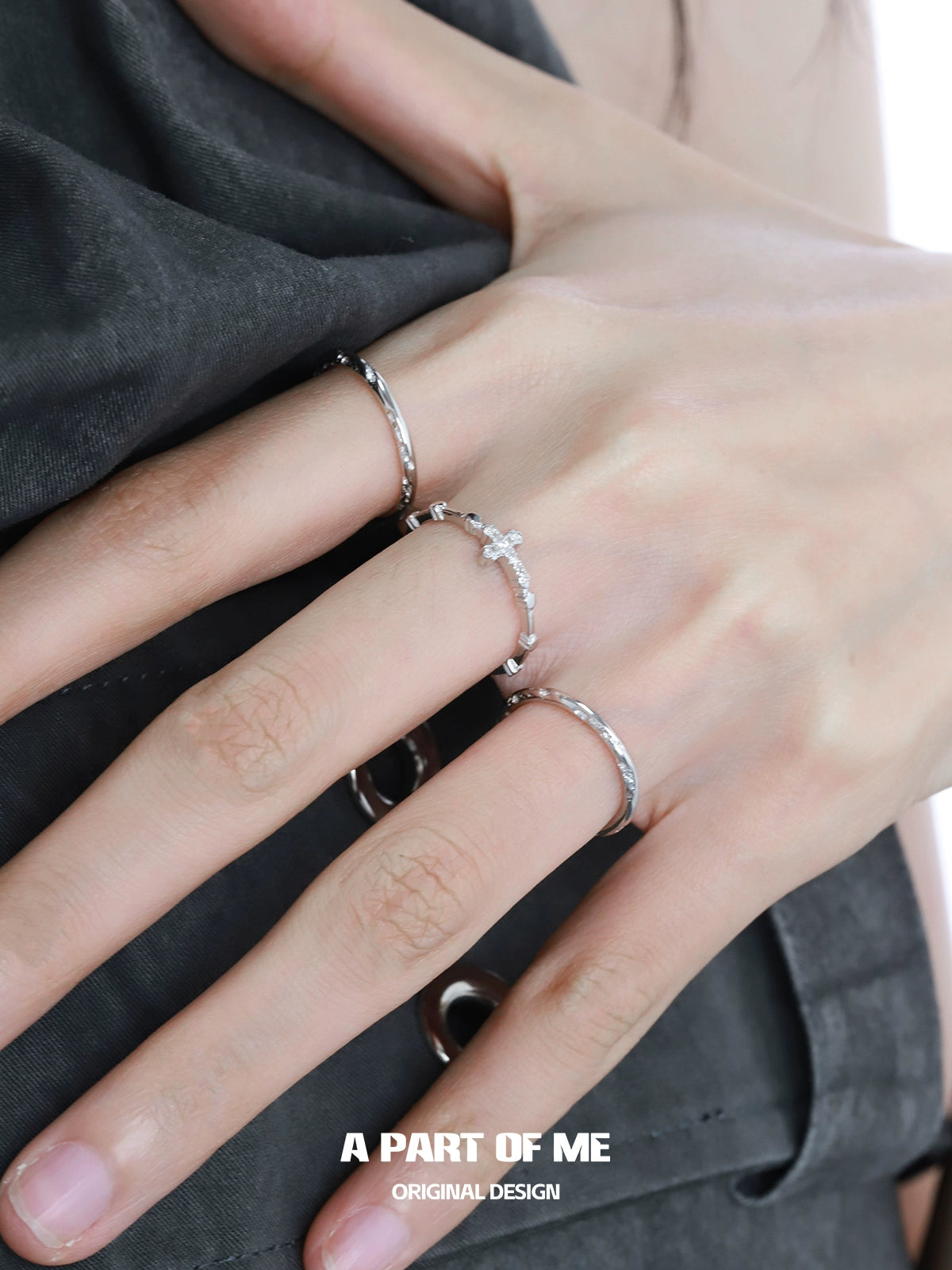 Two textured cross silver rings from A PART OF ME worn on a model's hand showcasing a stylish design