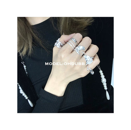 Stylish hand adorned with textured silver rings showcasing elegant design and intricate details