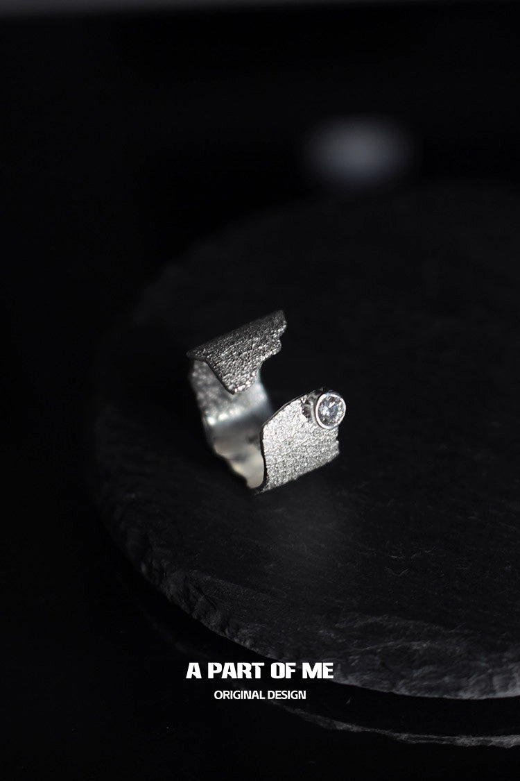 Textured silver travel ring with a unique design featuring a sparkling stone