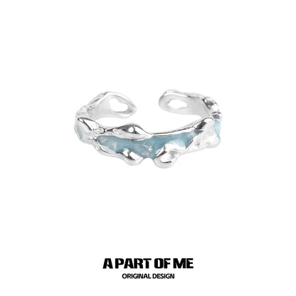 A PART OF ME white orchid love ring in silver with a unique twisted design and blue accents