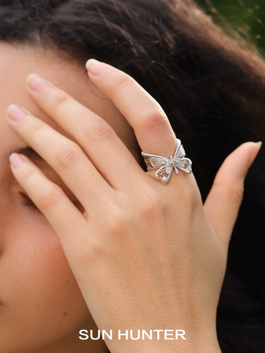 Elegant SUN HUNTER angel butterfly ring displayed on a model's hand, showcasing its intricate design
