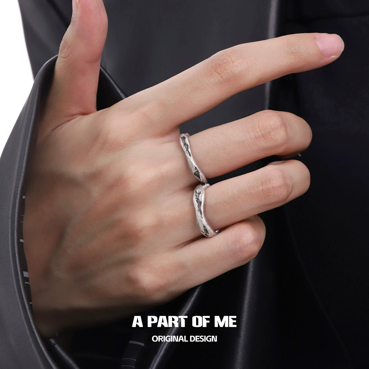 Unique geometric couple rings with a sculptural design worn on a hand in a black sleeve