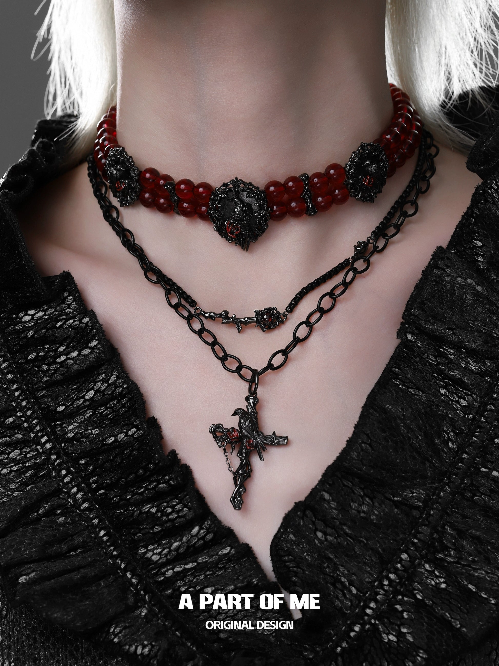 Gothic raven necklace layered with red beads and black chain for a dramatic style