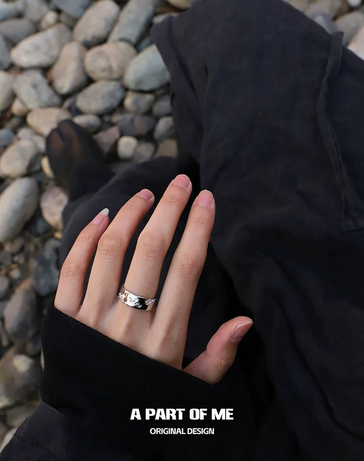 Stylish broken galaxy couple rings from A PART OF ME worn on hand against a rocky background