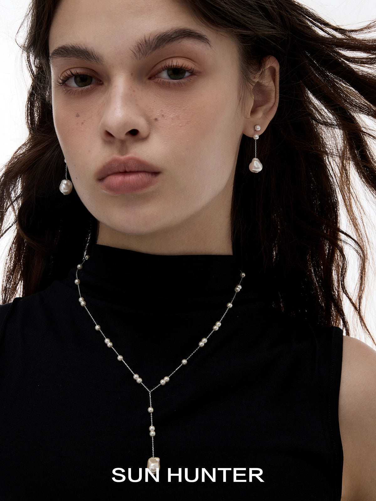 Elegant SUN HUNTER baroque pearl earrings dangling gracefully for a sophisticated look