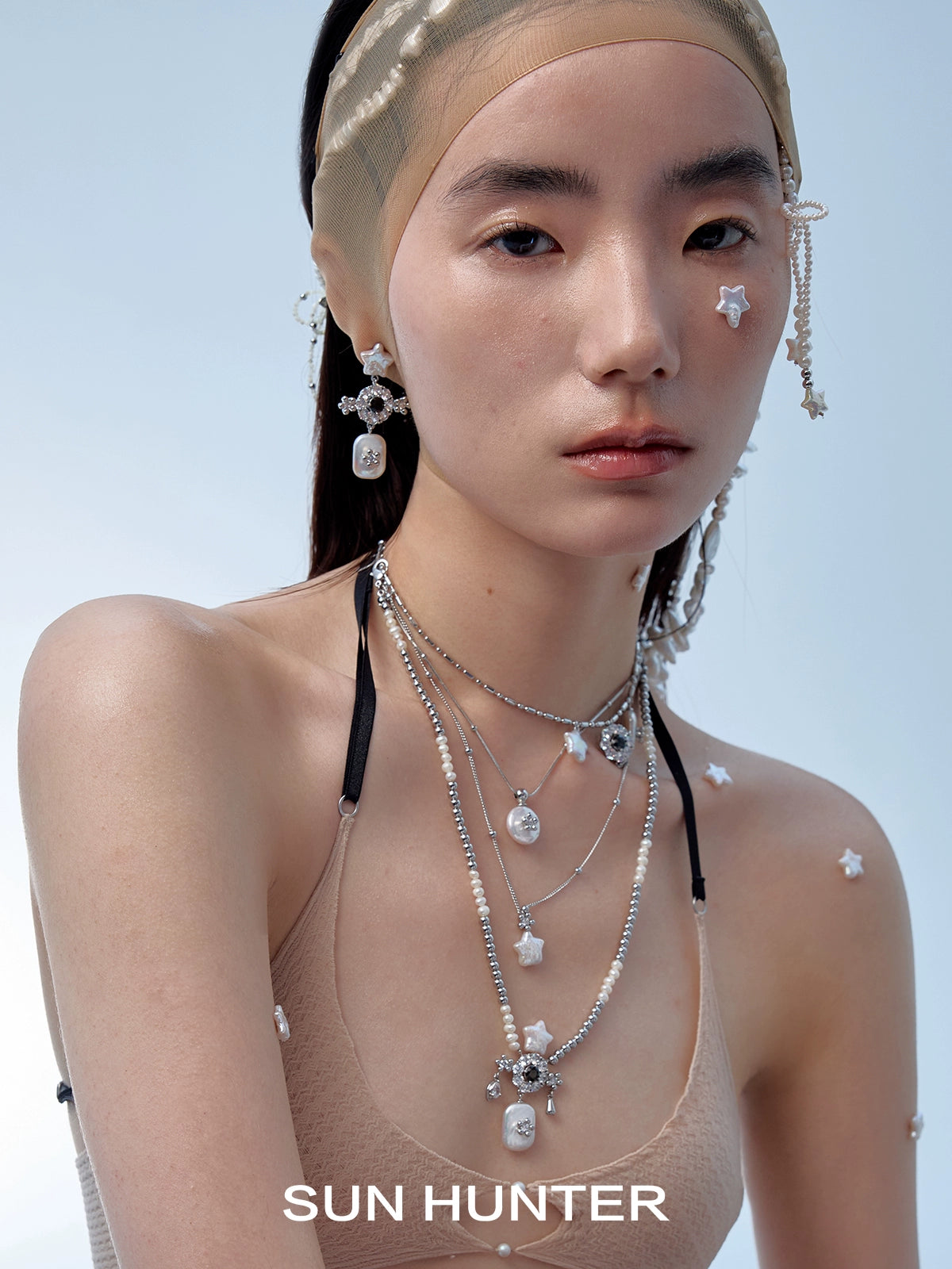 Model showcasing SUN HUNTER baroque pearl star earrings paired with delicate necklaces