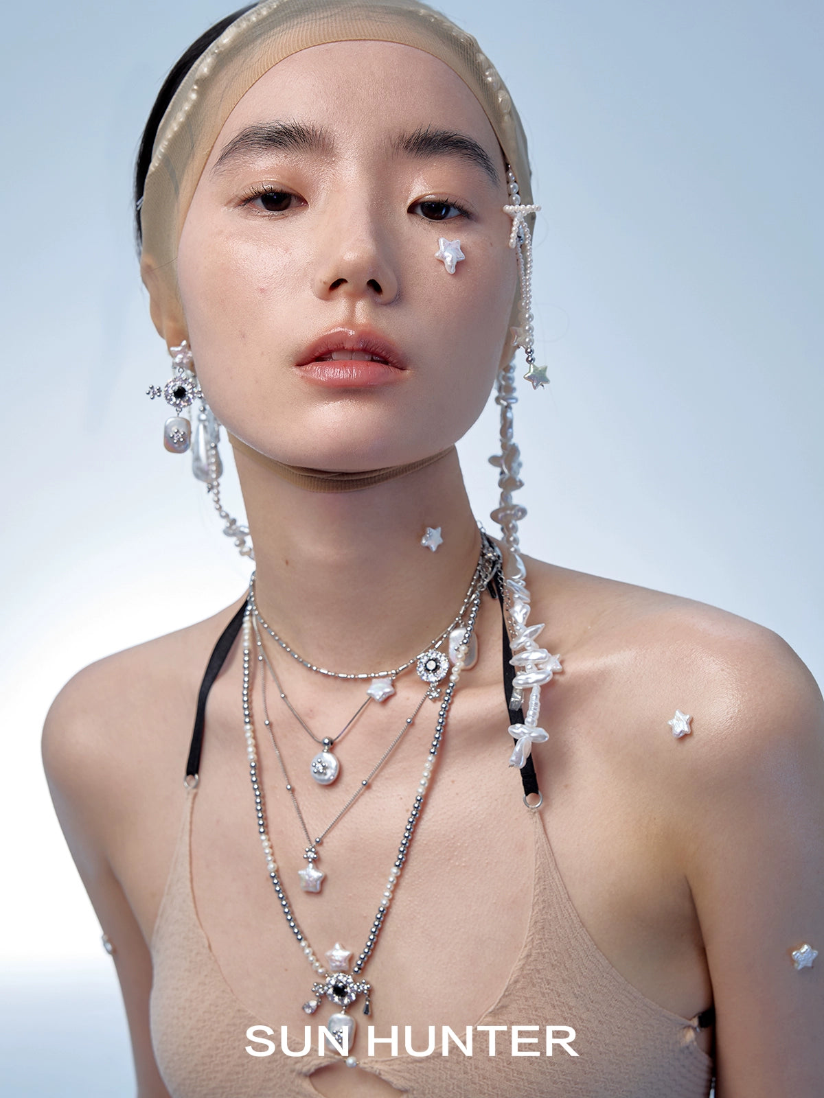 Elegant SUN HUNTER baroque pearl star earrings worn by model showcasing unique design and style