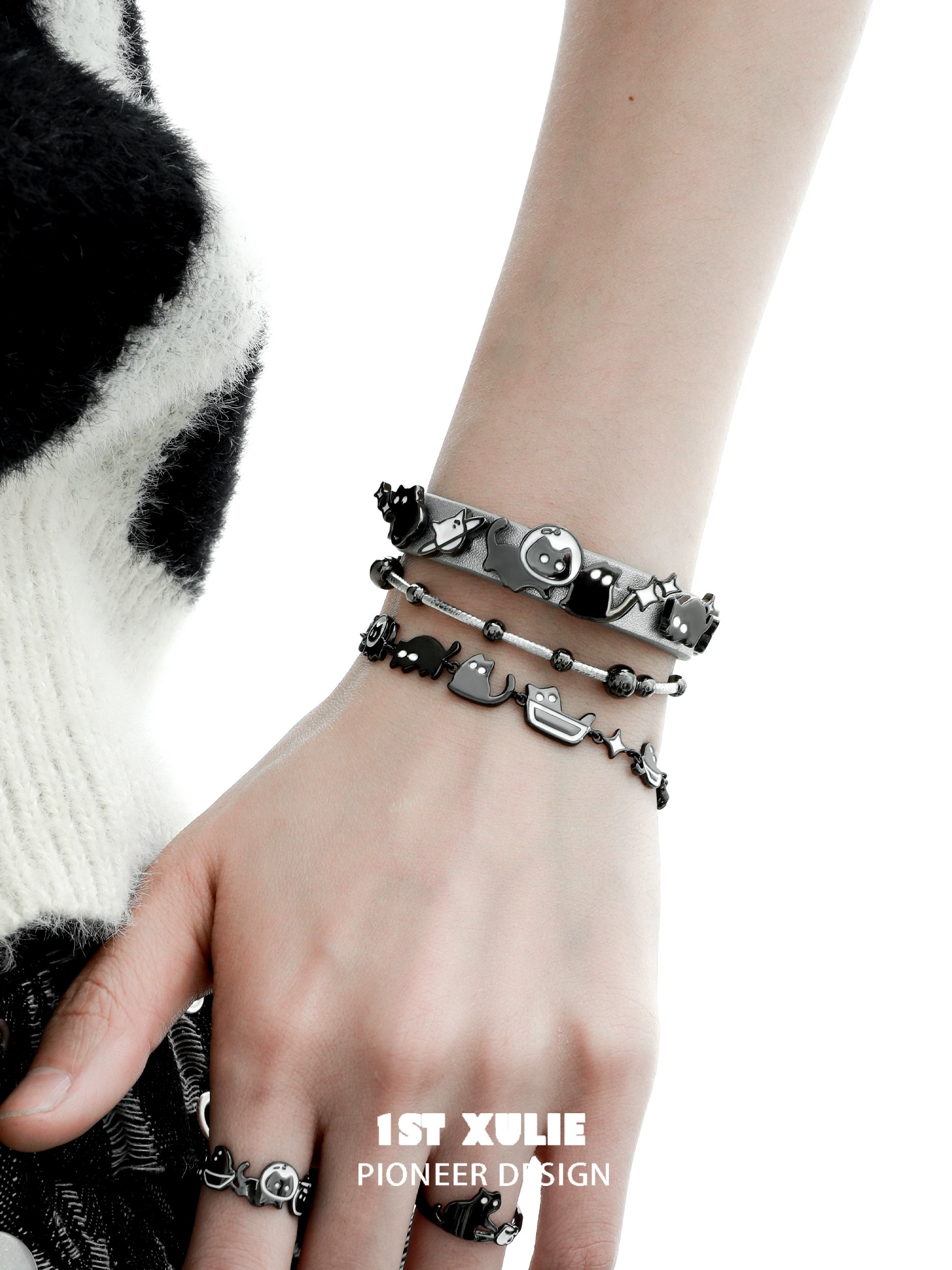 Trendy black cat bracelet set stacked on a hand, featuring cute feline designs for animal lovers