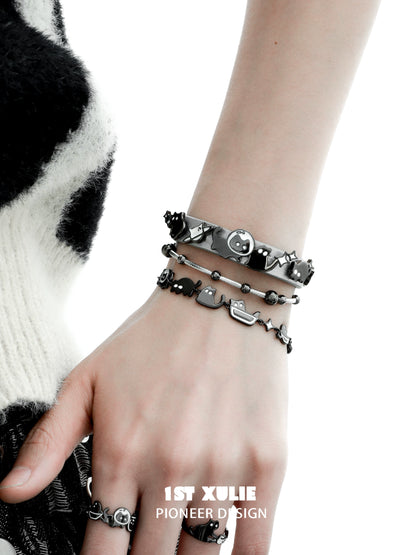 Trendy black cat bracelet set stacked on a hand, featuring cute feline designs for animal lovers