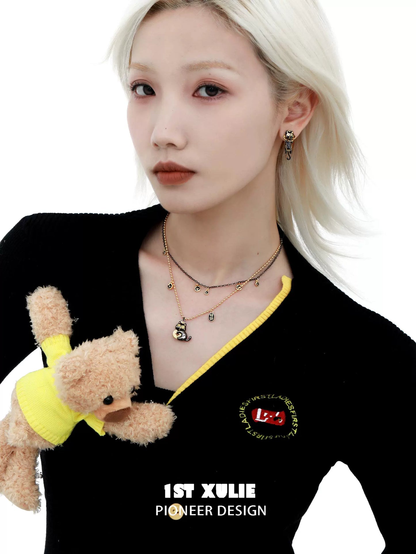 Stylish model wearing a black gold cat necklace layered with other delicate chains