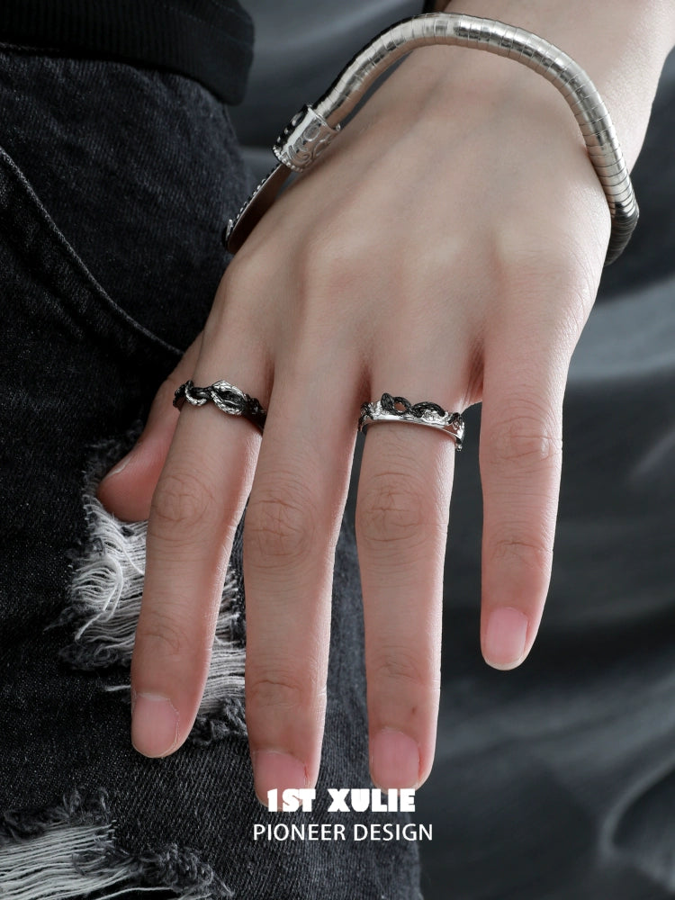 Stylish black snake couple rings on a hand with a snake bracelet and distressed jeans