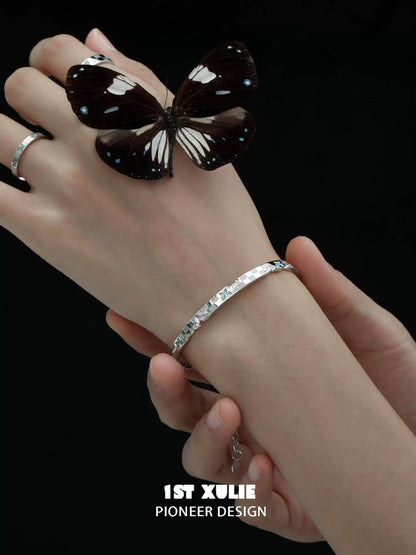 Elegant blue butterfly silver bracelet showcased on a hand with a butterfly perched nearby