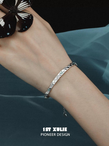 Elegant blue butterfly silver bracelet on a woman's wrist with a striking butterfly backdrop
