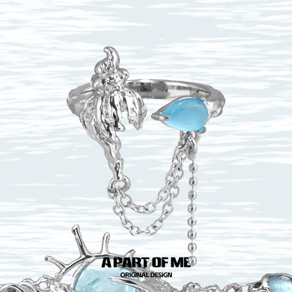 A PART OF ME blue conch chain ring featuring a unique design with a blue gemstone accent