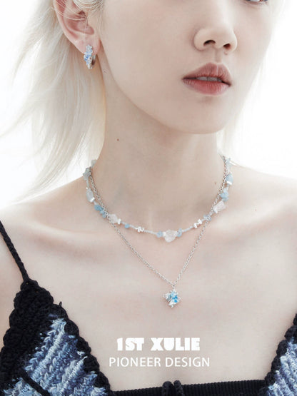 Stylish model wearing blue crystal ear cuffs paired with matching jewelry for a chic look