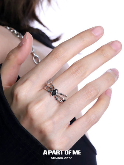 A PART OF ME bone spider ring featuring intricate design and an elegant black gemstone