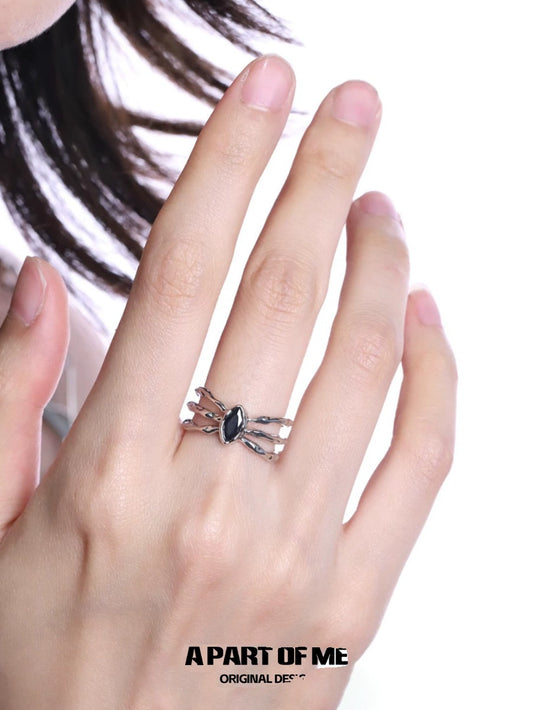 A PART OF ME bone spider ring displayed on a finger with a gothic design and black gemstone