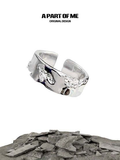 A PART OF ME broken silver ring with unique texture and original design showcased on a rocky background