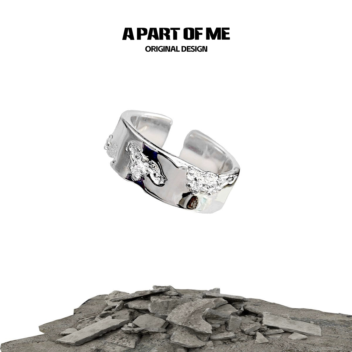 A PART OF ME broken silver ring with unique design showcased on a rocky surface