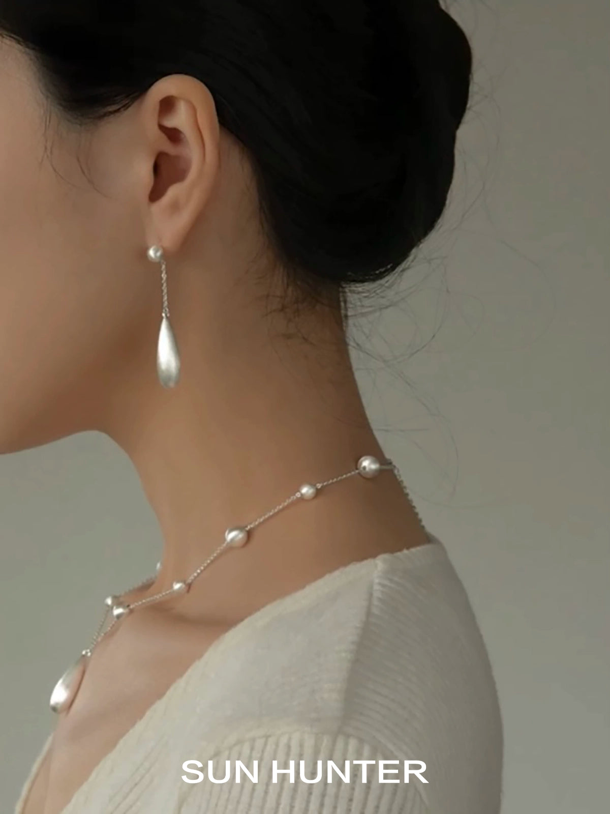 Elegant SUN HUNTER brushed teardrop earrings showcased on a model for a stylish look
