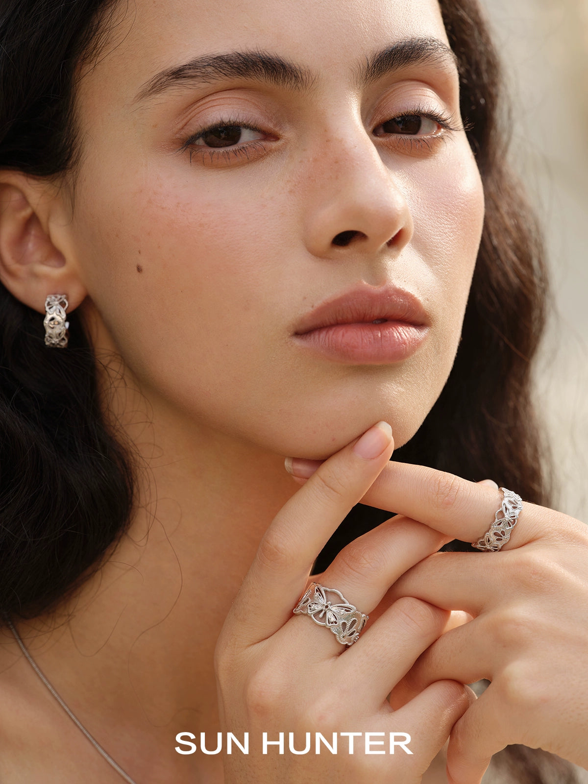 Model showcasing a SUN HUNTER butterfly hollow ring with elegant design and intricate detailing