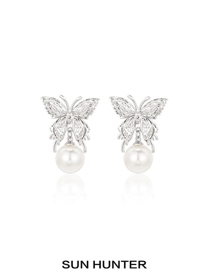 Elegant SUN HUNTER butterfly pearl earrings featuring a silver butterfly design and lustrous pearls