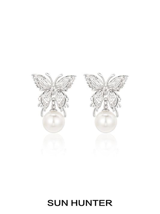 Elegant SUN HUNTER butterfly pearl earrings featuring a silver butterfly design and lustrous pearls